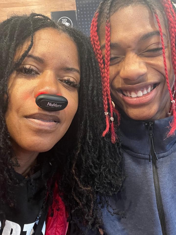 Joyce Simmons with her son smiling while she wears the NoMore® Colds device, review about staying healthy while her husband got sick and son using it for allergies